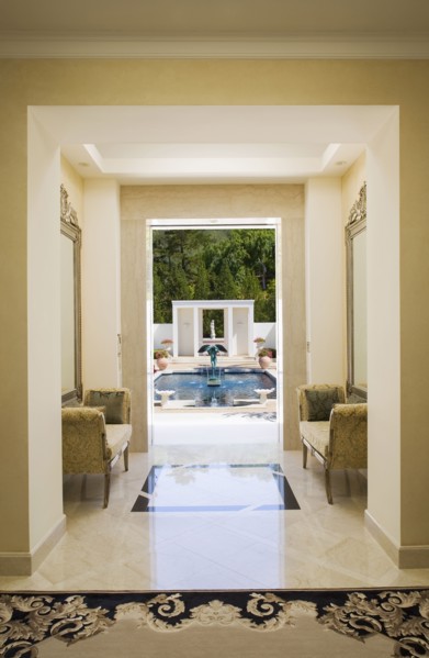 Interior of a marble hallway leading to a pool