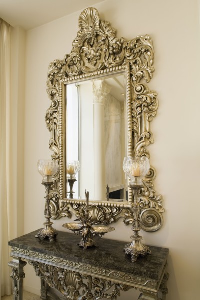Detail of a decorative mirror above a small side table