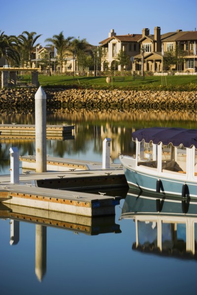 Boats docked at housing community near channel to ocean