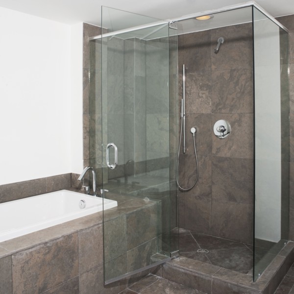 Glass doors of shower and bathtub in modern bathroom