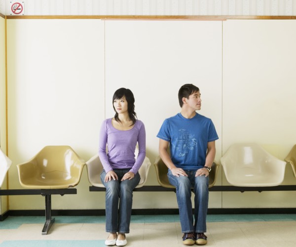 Asian couple sitting in waiting area