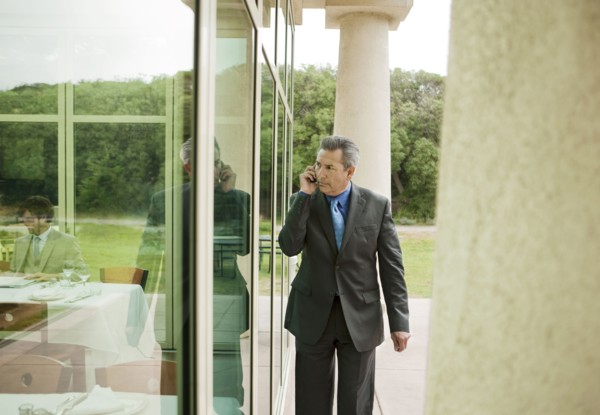 Suspecting Hispanic businessman talking on cell phone