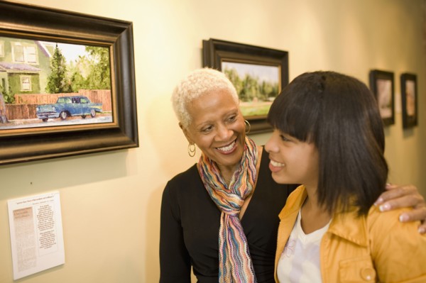 Grandmother and granddaughter hugging in gallery