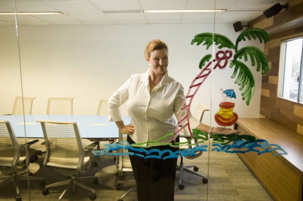 Caucasian businesswoman looking at drawing on conference room wall