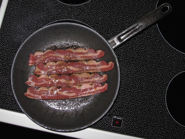 Bacon frying in pan on stove top