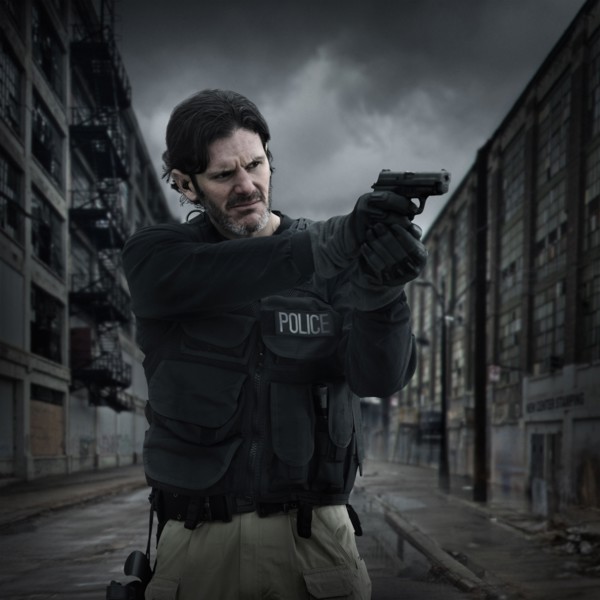 Caucasian policeman aiming gun on city street