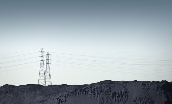Silhouette of power lines over rocky landscape