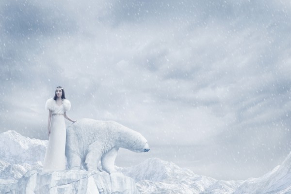 Woman and polar bear standing on glacier