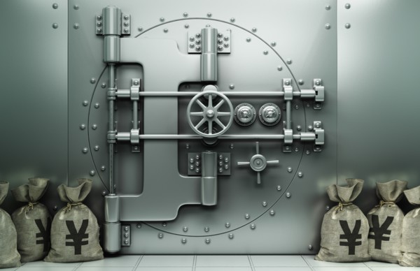 Money bags with yuan symbol on floor near vault