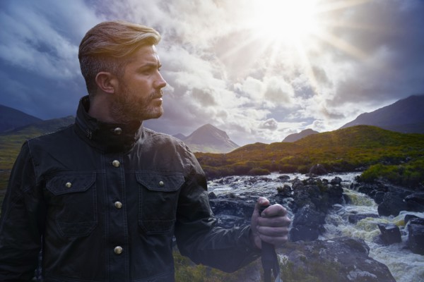 Caucasian hiker holding walking stick near river