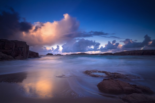 Calm waves on beach at sunset