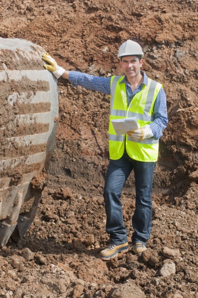 Hispanic construction worker standing in dirt
