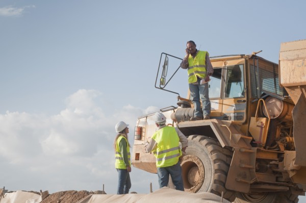 Hispanic construction workers near dump truck
