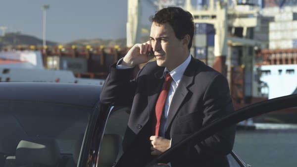 Hispanic businessman talking on cell phone on dock