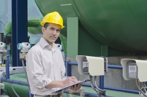 Hispanic worker checking machinery