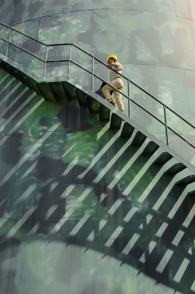 Hispanic worker climbing water tower