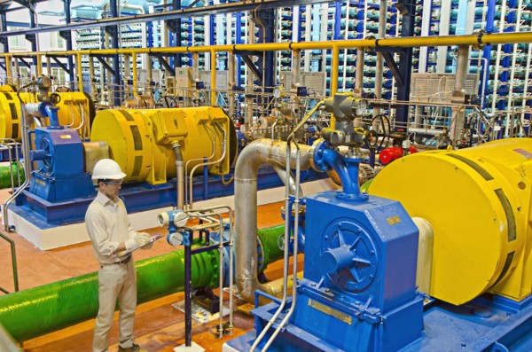 Hispanic worker checking machinery