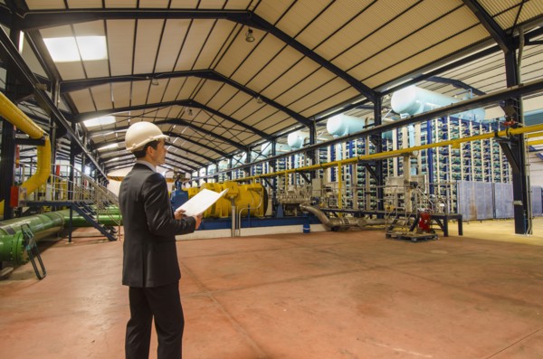 Hispanic businessman checking machinery