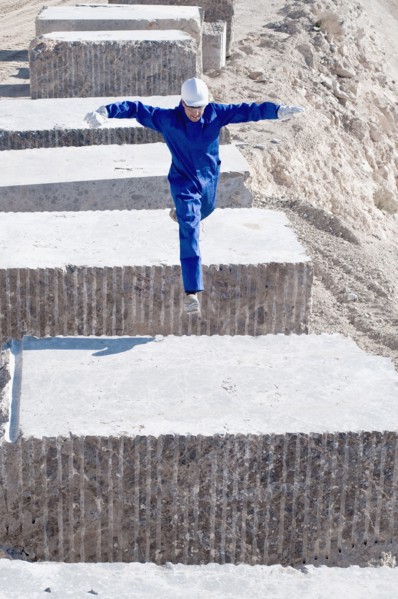 worker jumping between blocks of marble