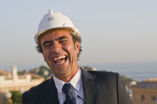 laughing businessman wearing hard hat