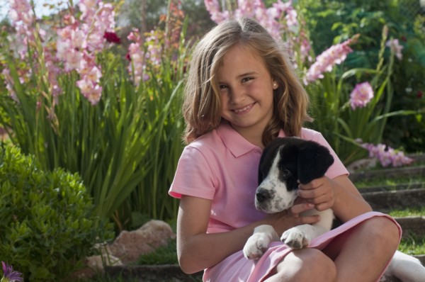 young girl with dog in garden
