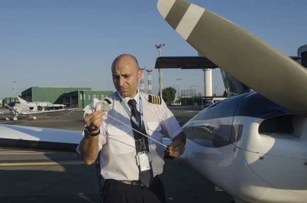 Pilot checking oil in airplane