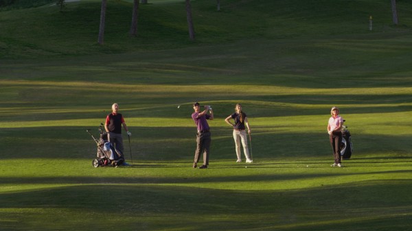 Caucasian friends playing golf on course