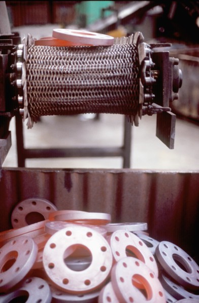 Glowing metal manufactured pieces on conveyor belt