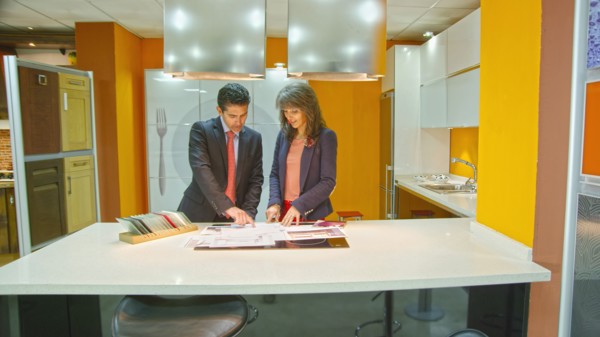 Hispanic salesman showing client samples in kitchen