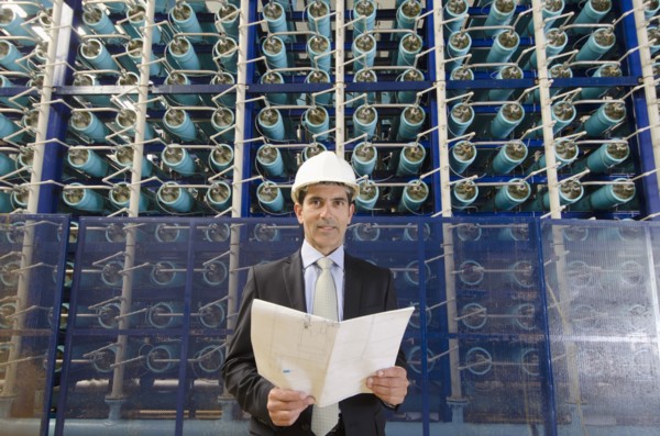 Hispanic businessman smiling in power plant
