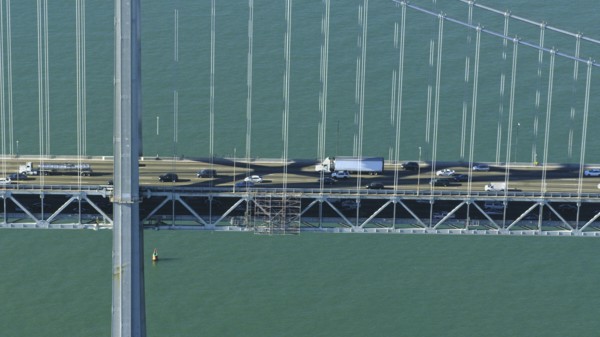 Aerial view of cars and trucks driving on bridge