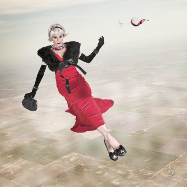 Woman in evening gown with glass of wine floating in sky
