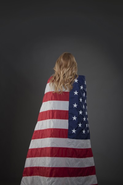 Mixed race woman wrapped in American flag