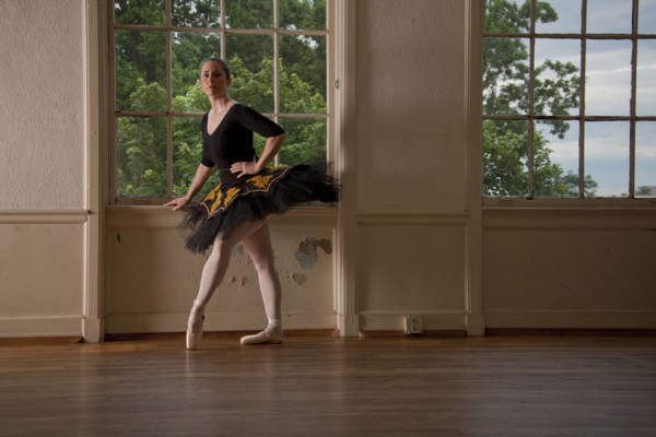 Caucasian ballerina posing at window in studio