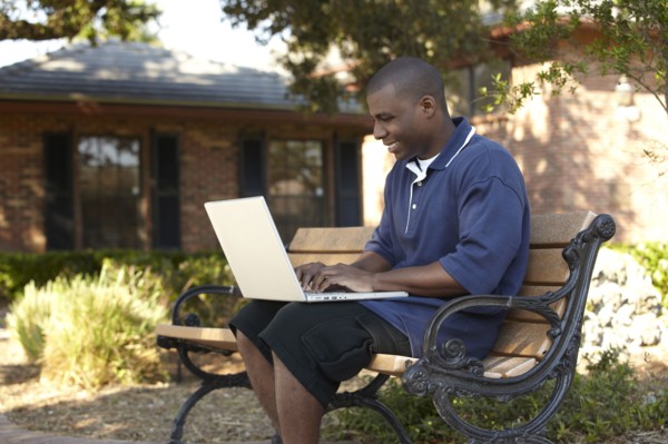 Black man typing on laptop