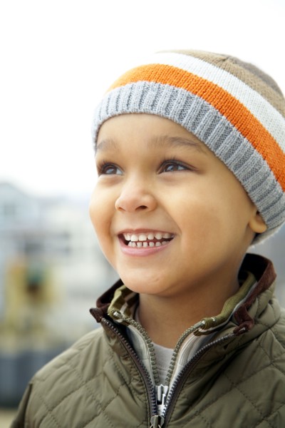Mixed race boy in cap outdoors