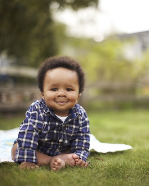 African American baby sitting in grass