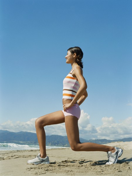 Mixed race woman exercising on beach