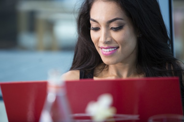 Hispanic woman using laptop in cafe