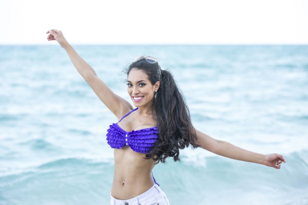 Hispanic woman playing in ocean