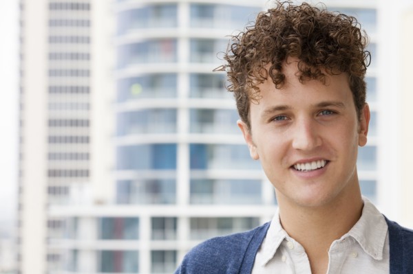 Caucasian man smiling on urban balcony