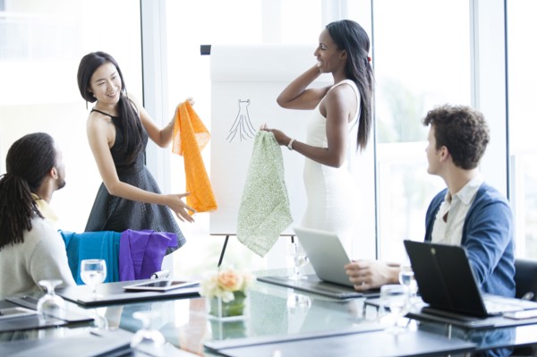 Business people examining fabric samples in office meeting