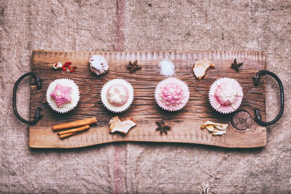 Cupcakes on ingredients on wooden tray