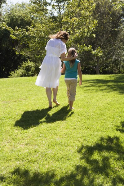 Mother and daughter walking together in grass