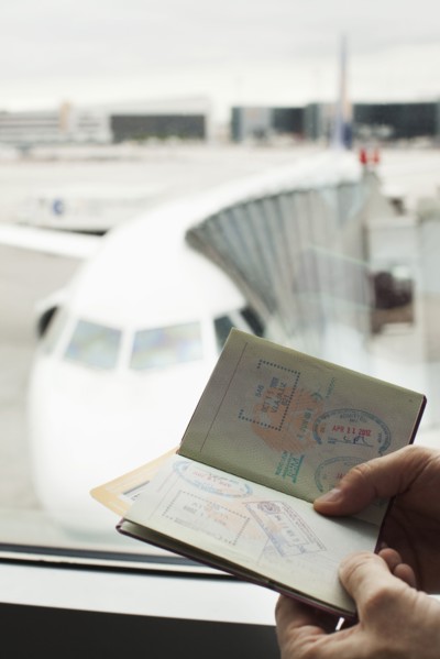 Caucasian man looking at passport in airport