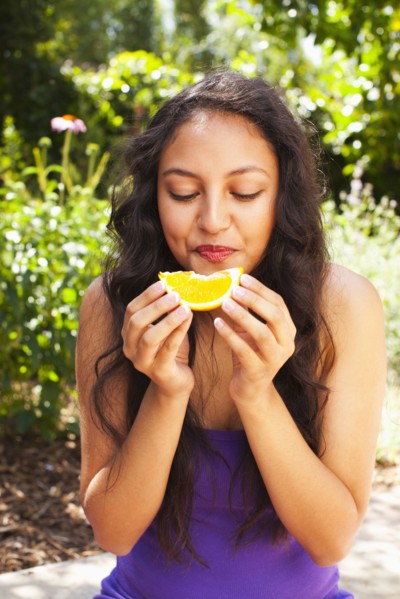 Mixed race teenager eating orange