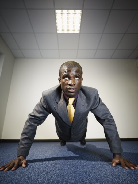 Black businessman doing push-ups
