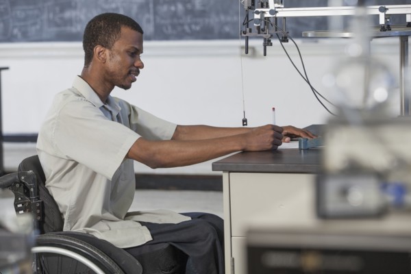 African American paraplegic student working in science classroom