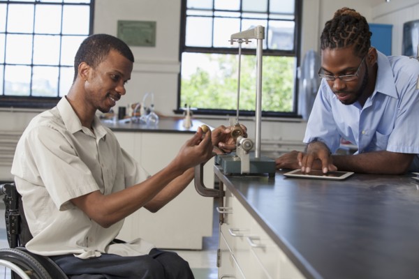 Paraplegic student and classmate working in science classroom