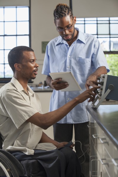 Paraplegic student and classmate working in science classroom